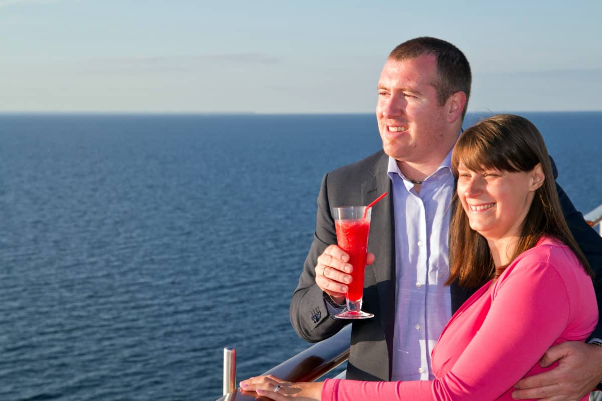 Couple of cruise ship balcony admiring sea view