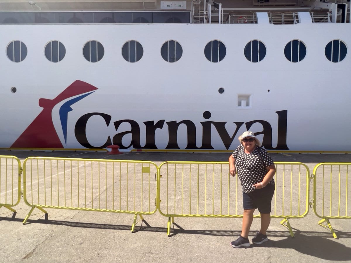 CruiseNonstop writer Morag Hutchison posing in front of a Carnival Cruise Ship
