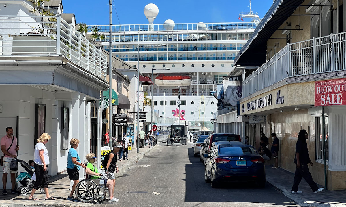 Main street in Nassau looking down towards cruise port with cruise ship in the background.